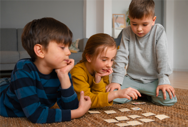 Children practicing fine motor skills with beading and tracing tools